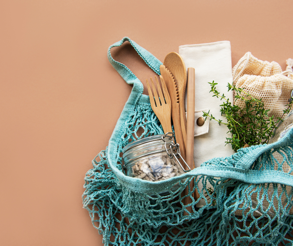 Image of a blue string bag filled with a glass jar, wooden cutlery and other items