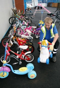 A member of staff at Pinbrook Recycling Centre sorts our children's ride on toys for resale in the Reuse Shop