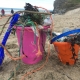 Child's plastic bucket on beach full of plastic litter