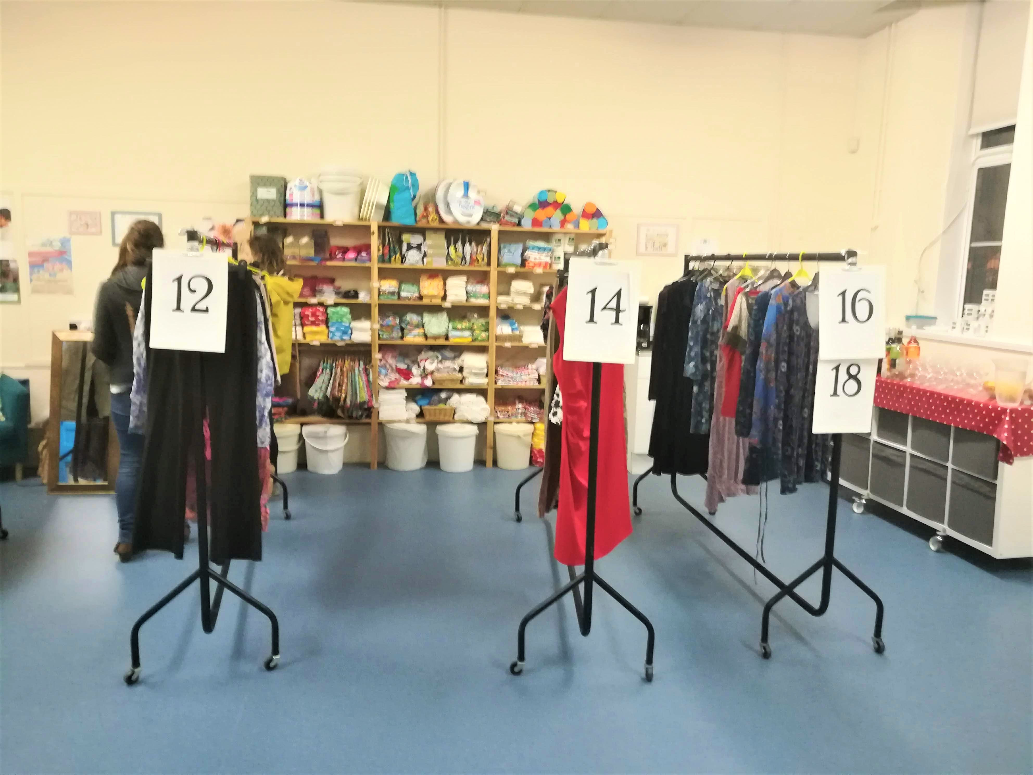 Rails of clothes separated into different women's sizes at a clothes swish at Marpool Primary School
