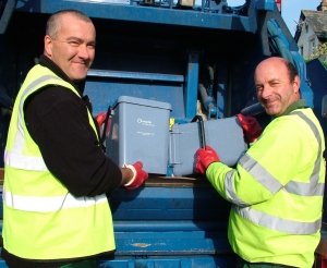 Smniling waste collection team from West Devon emptying food waste caddies into a waste collection vehicle