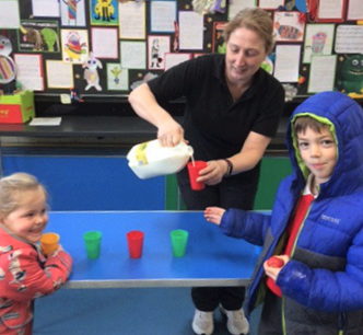 Keri Lambert, school dinner assistant at Georgeham Primary School pouring milk for pupils at Devon's first Plastic Free School