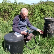 An Inspector using monitoring equipment to measure gas from a redundant landfill site