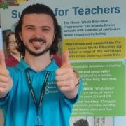 Oliver in a blue work t-shirt giving a thumbs up.