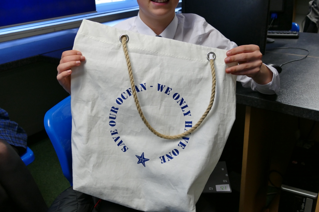 Young person holding up a bag made from Sailcoth.