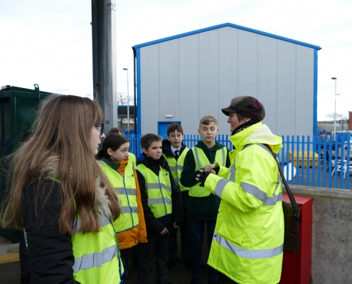 Young people listening to Waste Educator Sally Jackson explain recycling and 3Rs on a school trip