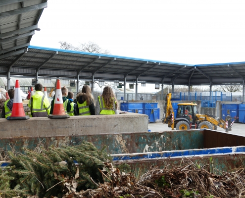 Picture of a group of schoolchildren standing beside the green waste skip at Pinbrook Recycling Centre