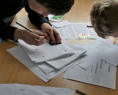 Young person drawing on a sheet as part of the Trading Game