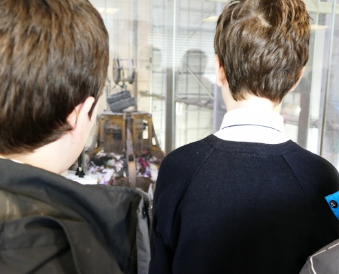 Backs of pupils heads looking at the grabber at Exeter EfW