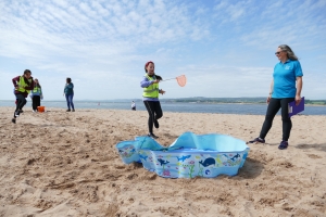 Child running towards a paddling pool with a net