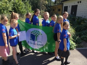 Group of children at Sparkwell school holding up their EcoschoolsGreen Flag