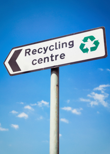 A sign for a public recycling centre, with a green recycling symbol.