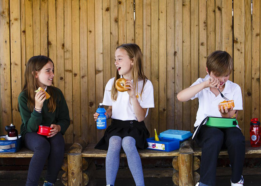 3 children enjoying their packed lunches