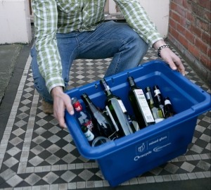 Man recycling glass in a kerbside container