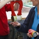 Child and waste educator Sally with magnet separating steel can from aluminium can