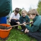 Crouched children around a container of compost beside Ridan composter