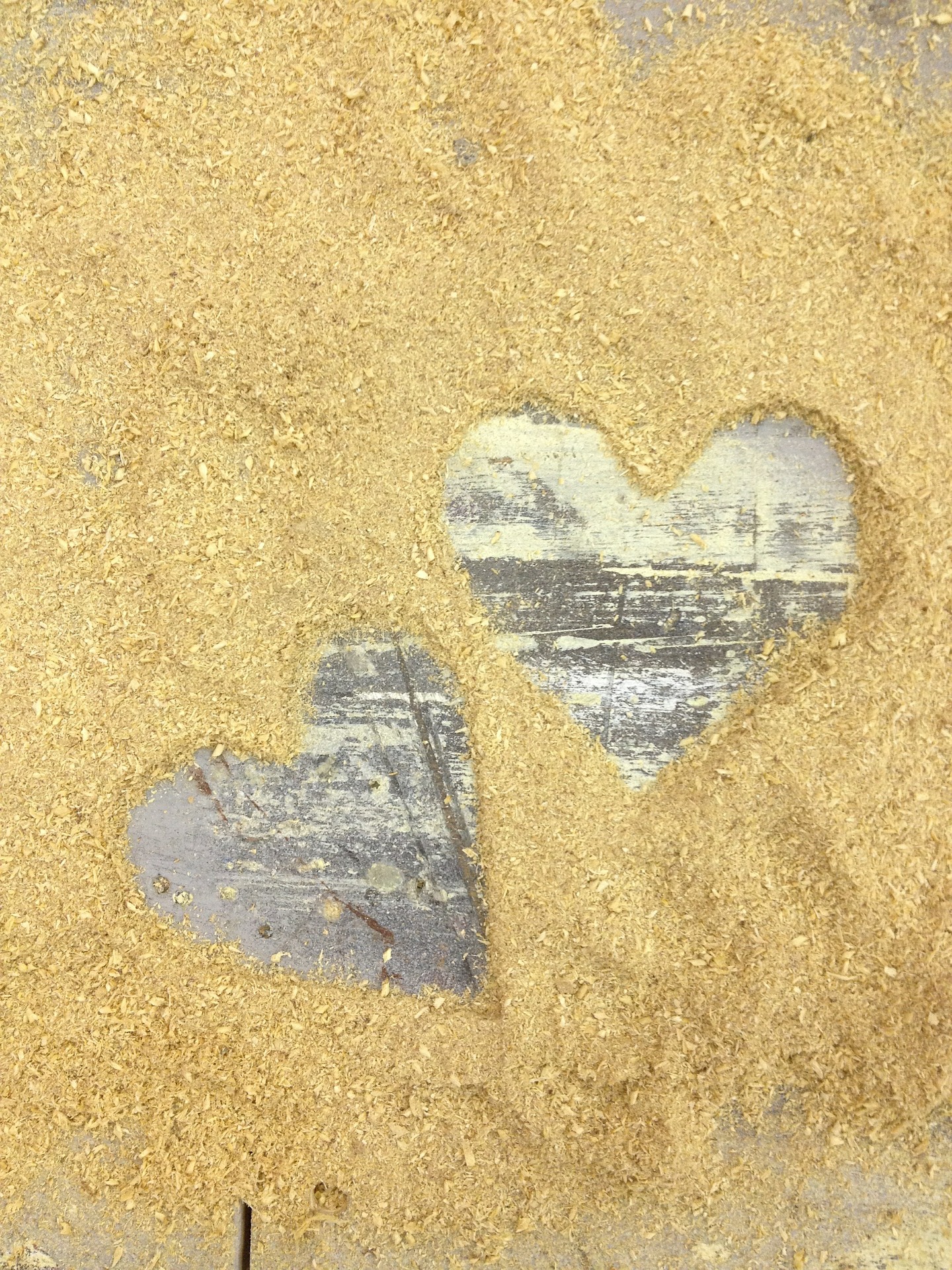 a picture of hearts etched with sawdust on a plank of wood