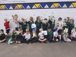 Group of children at St Peters Primary School in Budleigh Salterton standing and sitting showing off their bee pictures and posters