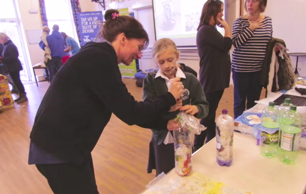 Pupil being shown how to make an Eco-Brick at st Peter's Primary School Eco-Day