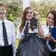 Smiling secondary students with bag of rubbish, scales and clipboard