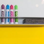 Close up of whiteboard with coloured whiteboard pens and board rubber