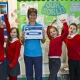 Cheering schoolchildren and Waste Educator Sally holding a certificate