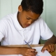 Child sat at desk with paper and pen